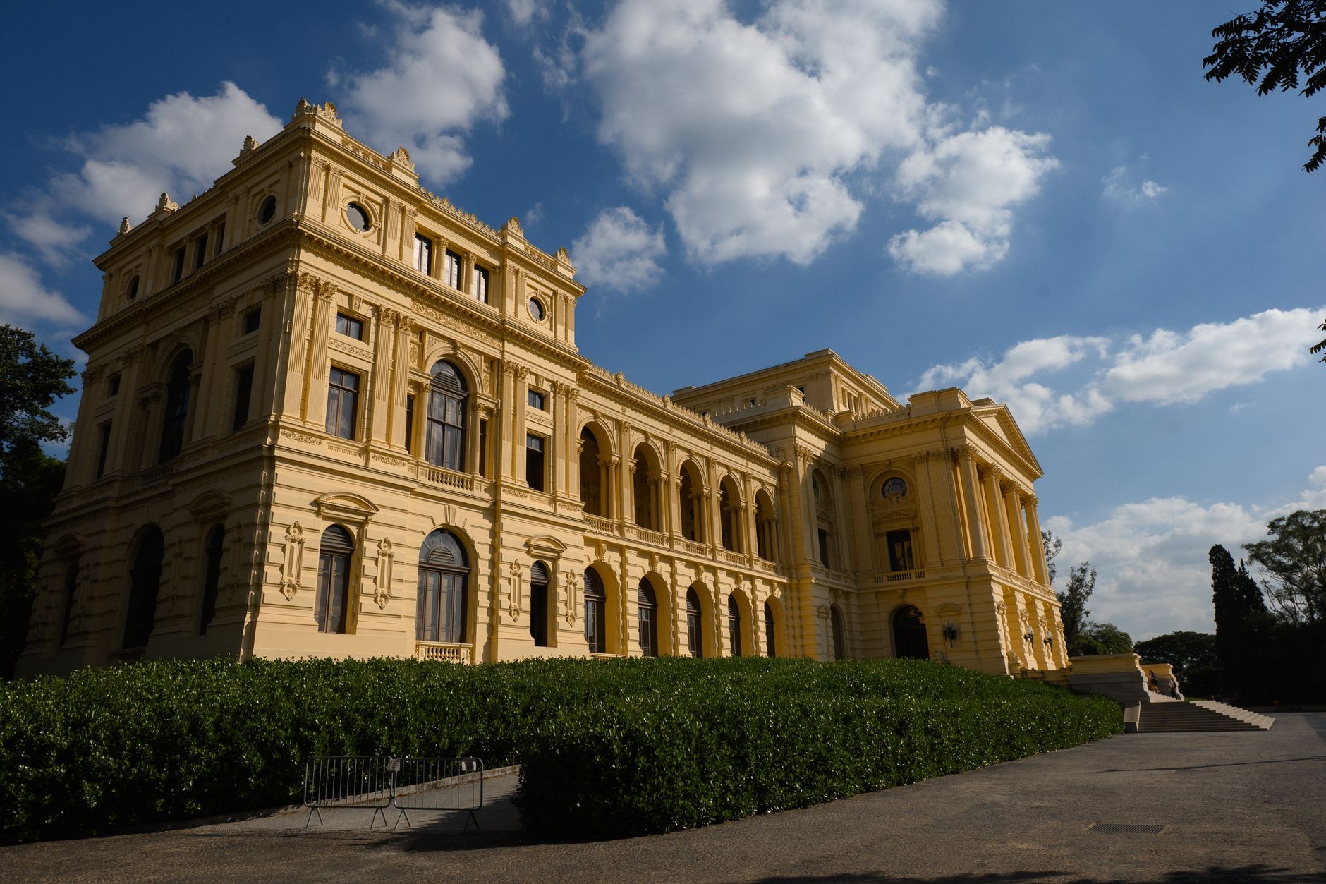 Elegant historic yellow building under bright blue sky, captured in daylight.