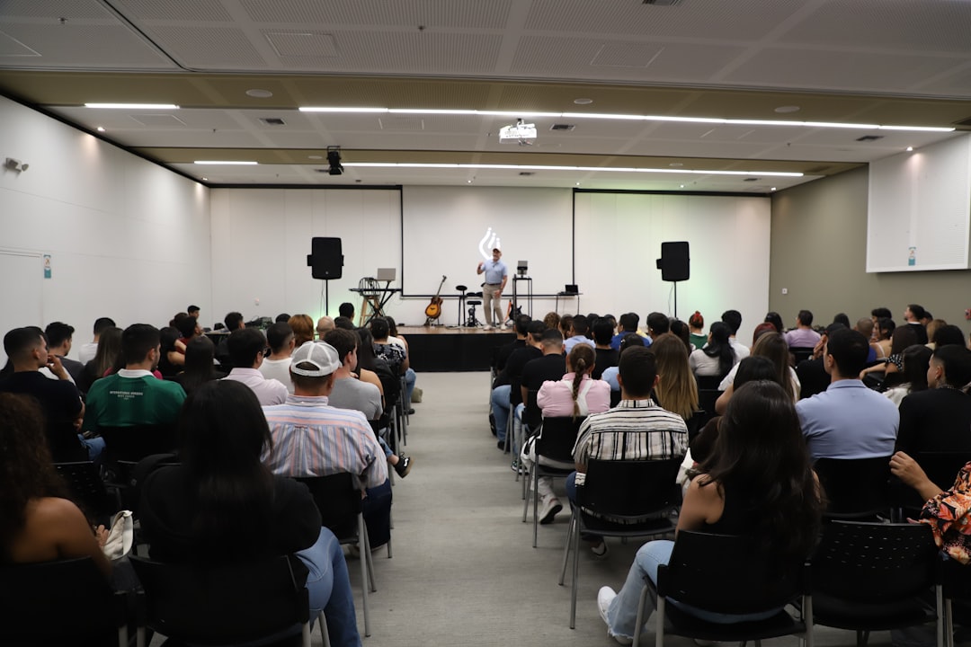 As Pessoas Assistem A Uma Apresentacao Em Um Salao De Conferencias VYNXPzVs7DU