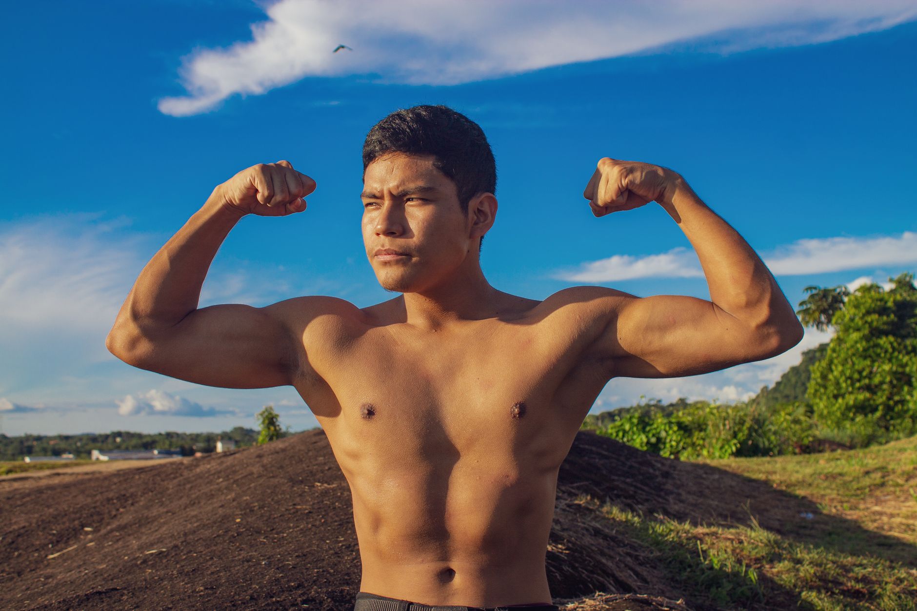 Muscular man flexing his arms outdoors in São Gabriel da Cachoeira, Brazil.