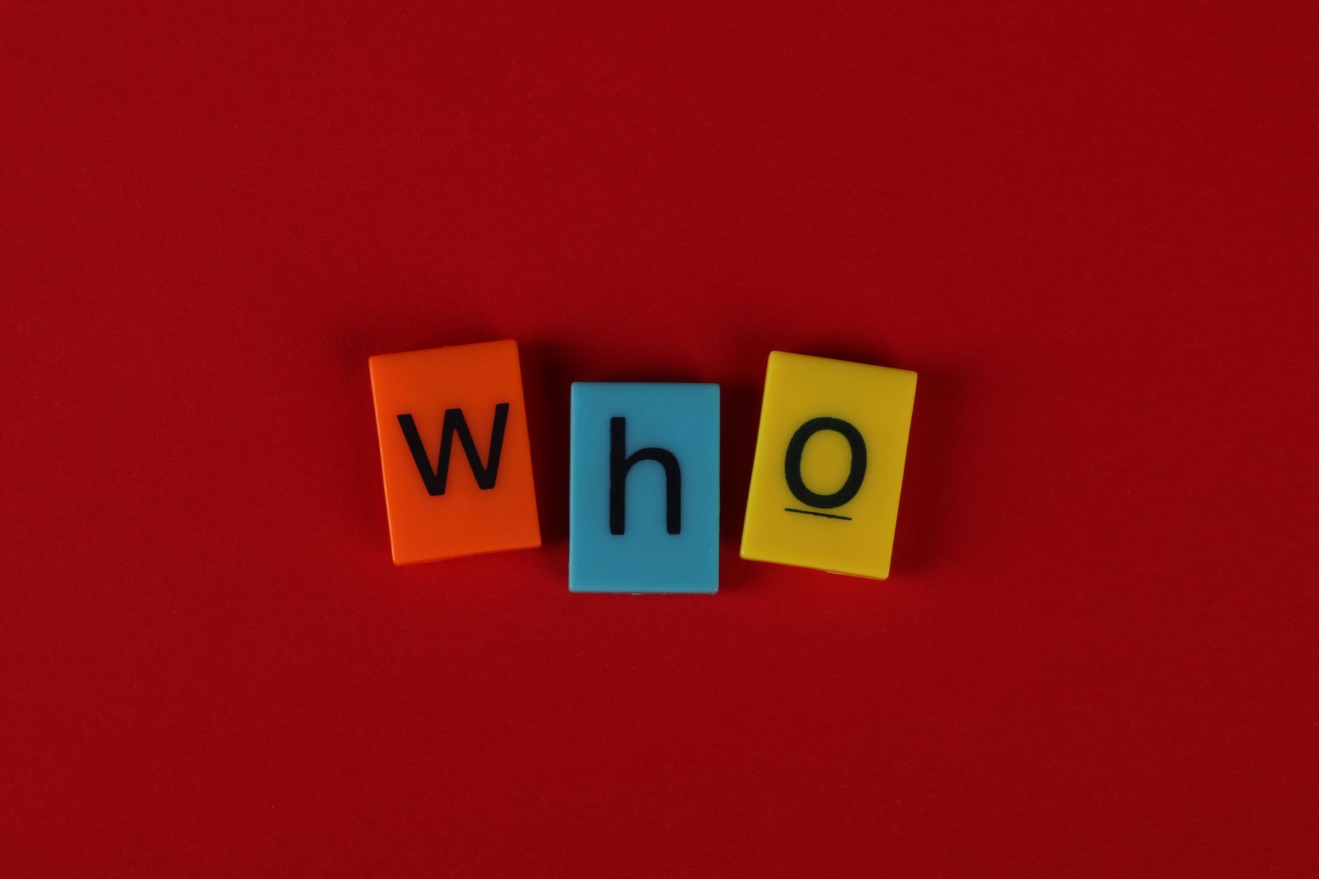 Alphabet blocks forming the word 'who' against a vibrant red backdrop.