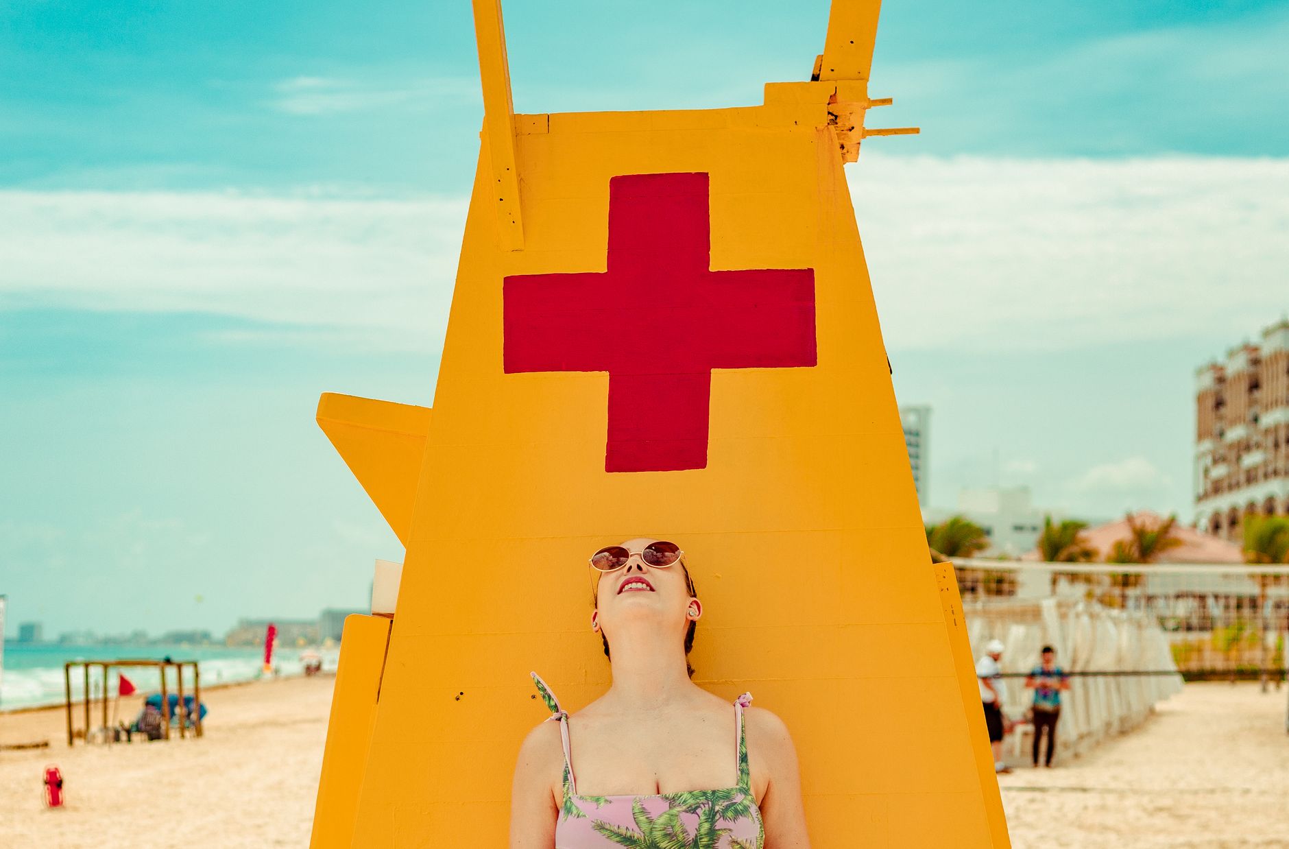 Woman enjoys sunny day by colorful lifeguard tower on Cancun beach