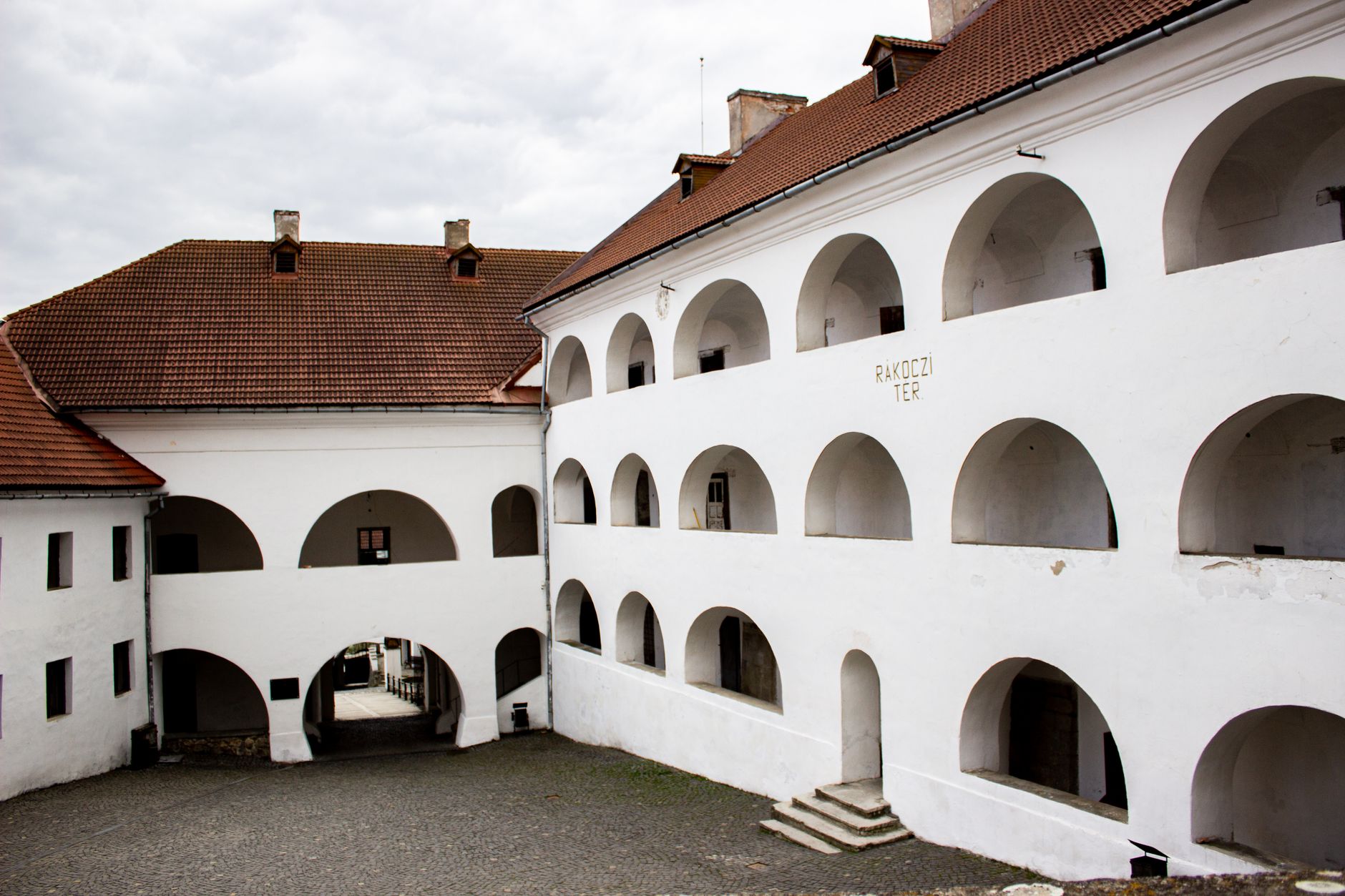 Arched courtyard view of a traditional European castle, highlighting architectural symmetry.