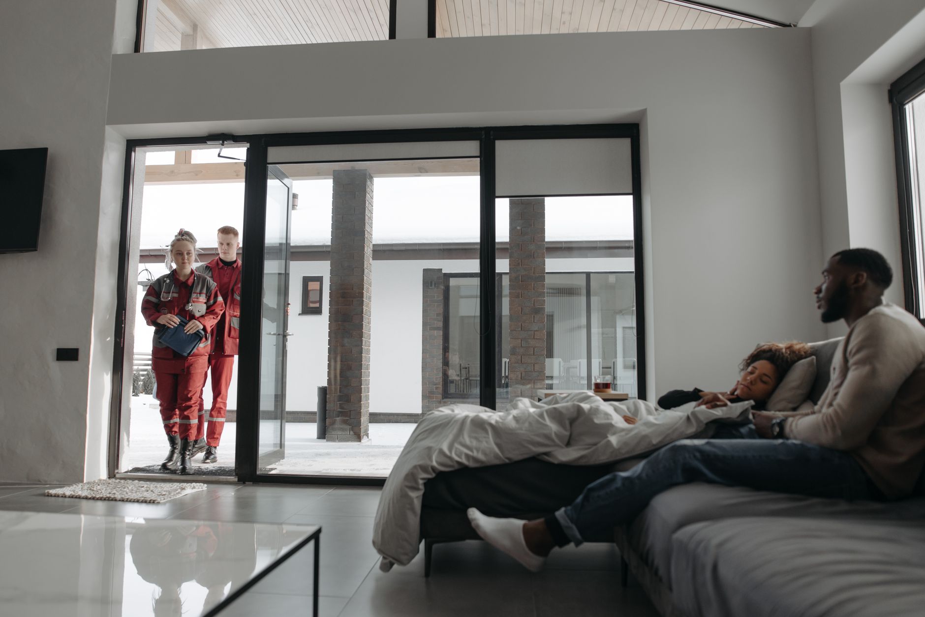 Paramedics attending to a sick person at home, showcasing urgent healthcare assistance.