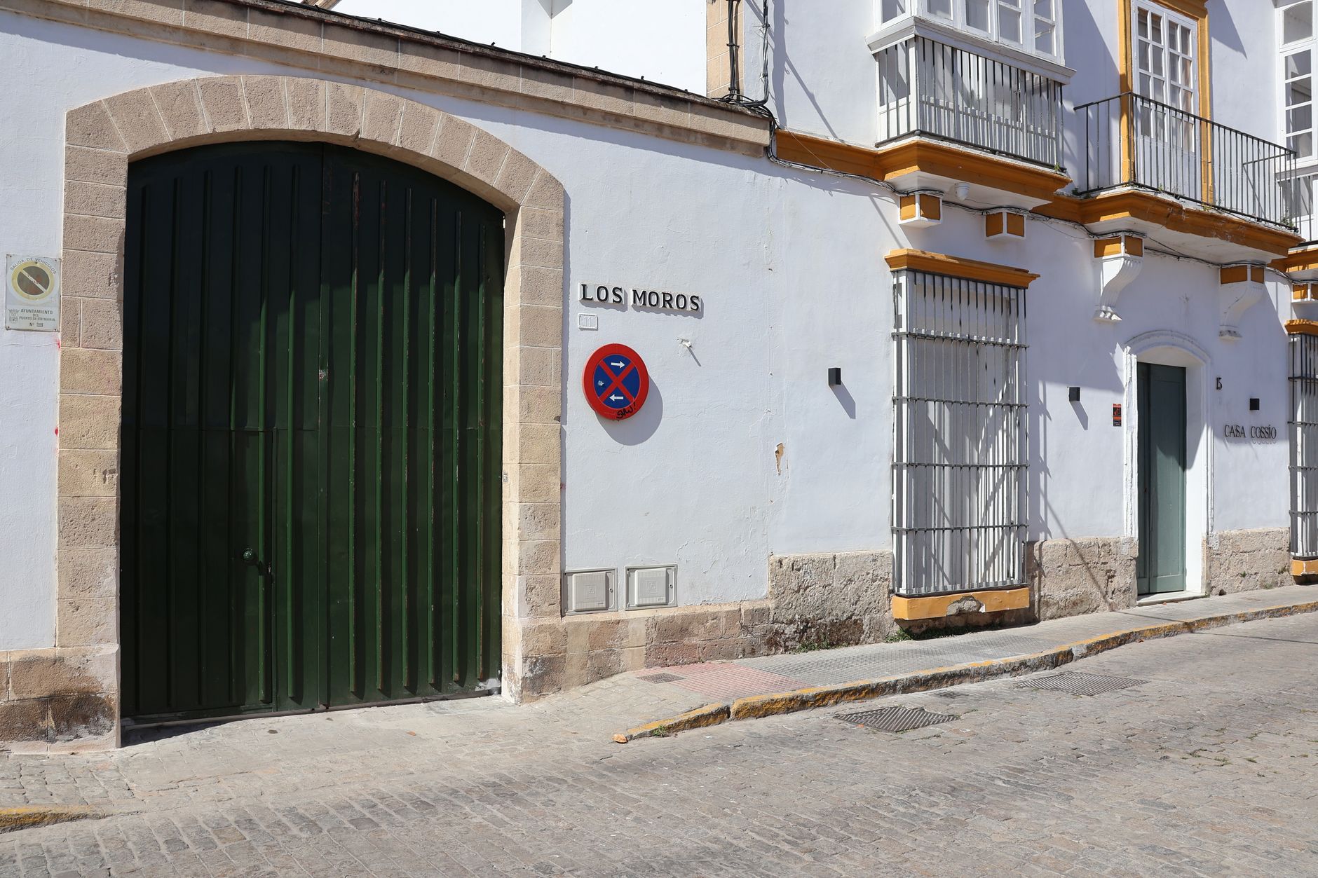 Whitewashed building façade with green door in Andalucía, Spain.