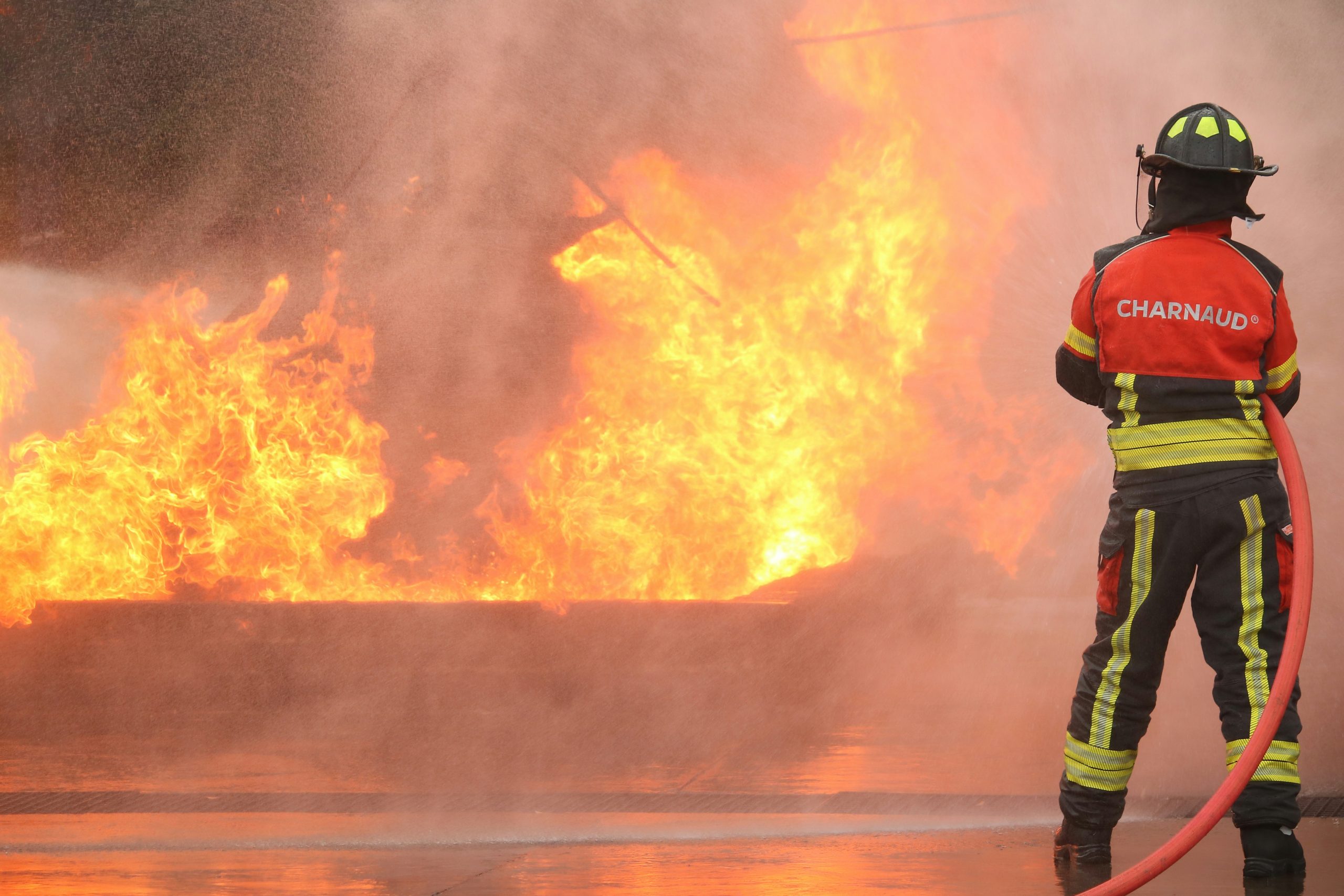 A firefighter watches a large fire burn.